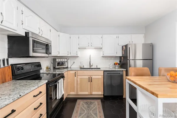 a kitchen with stainless steel appliances granite countertop a refrigerator stove microwave and sink