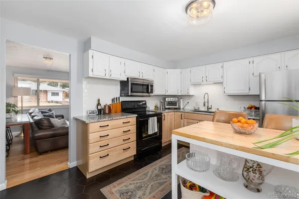 a kitchen with stainless steel appliances granite countertop a sink stove and cabinets