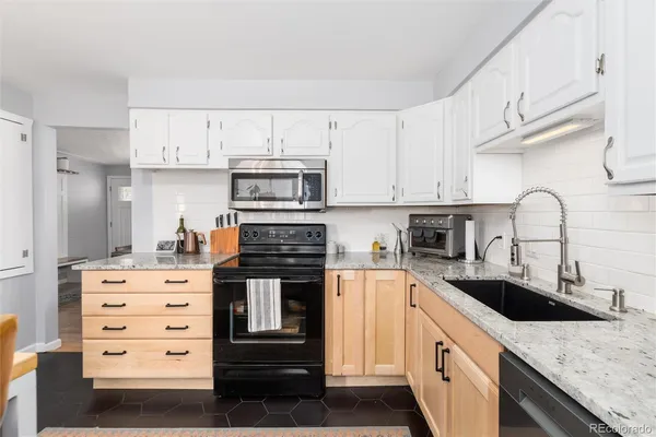 a kitchen with granite countertop a sink and cabinets