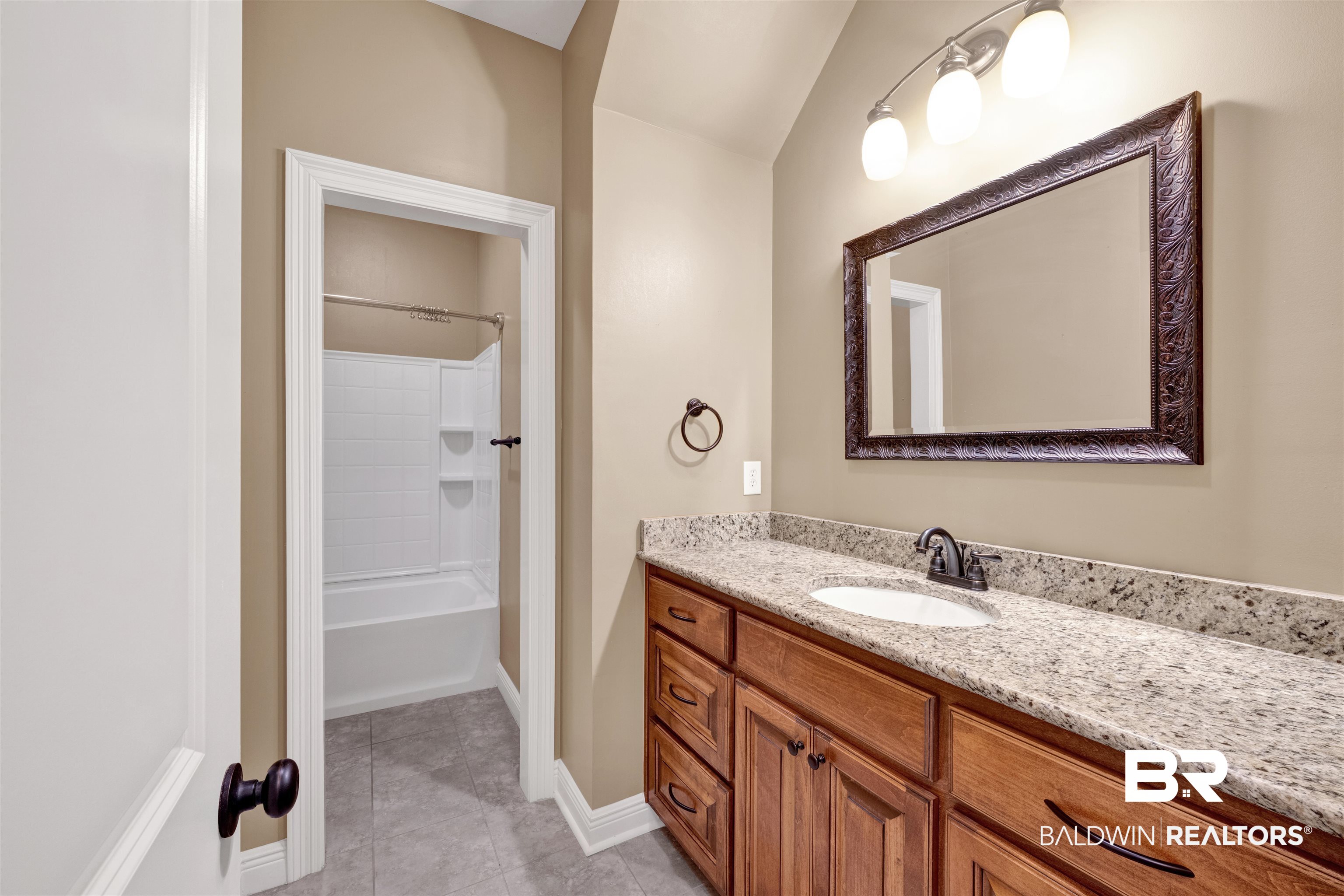 12944 Anna's Way Stapleton, AL 36578 - Photo 58 of 64 Bathroom vanity featuring a light-toned stone countertop, an undermount sink, and a dark bronze faucet