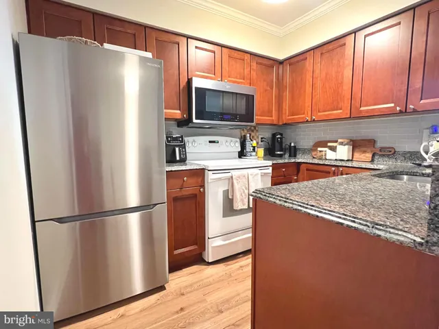 a kitchen with stainless steel appliances granite countertop a refrigerator microwave and sink