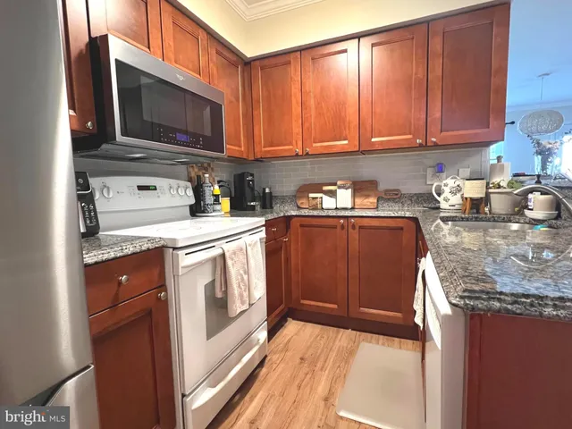 a kitchen with stainless steel appliances granite countertop a stove a sink and a microwave