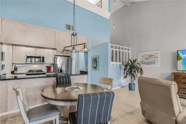 a kitchen with stainless steel appliances a table and chairs in it