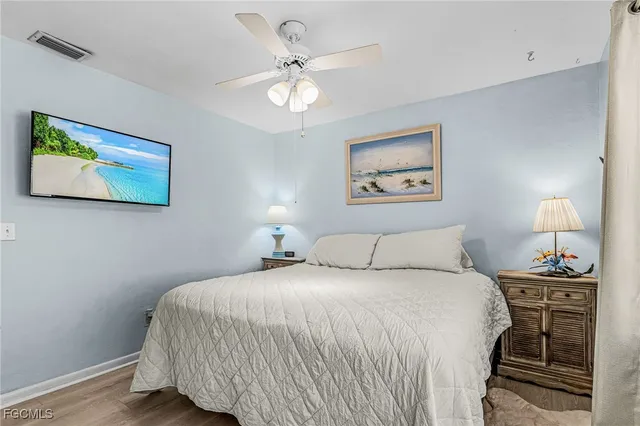 a bedroom with a bed and a lamp on dresser