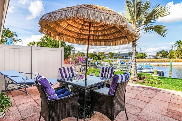 a view of a chairs and table in patio with a barbeque