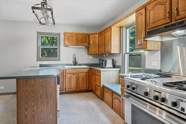 a kitchen with stainless steel appliances granite countertop a stove a sink dishwasher and a refrigerator