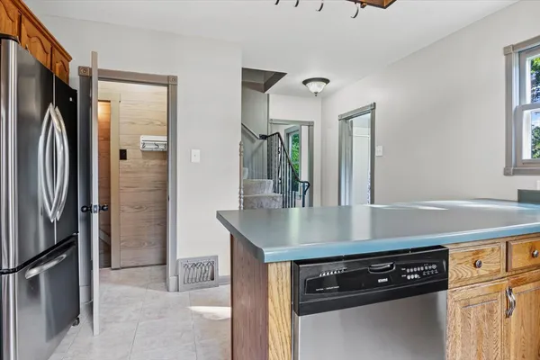 a kitchen with stainless steel appliances a sink a stove a refrigerator and cabinets