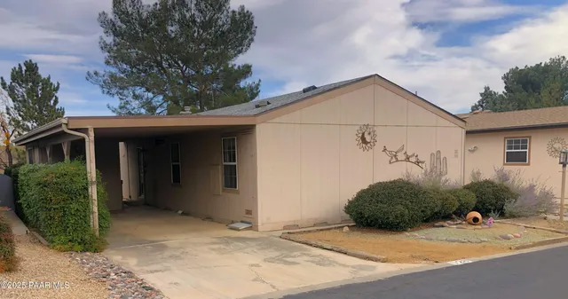 a view of a house with a small yard plants and large tree