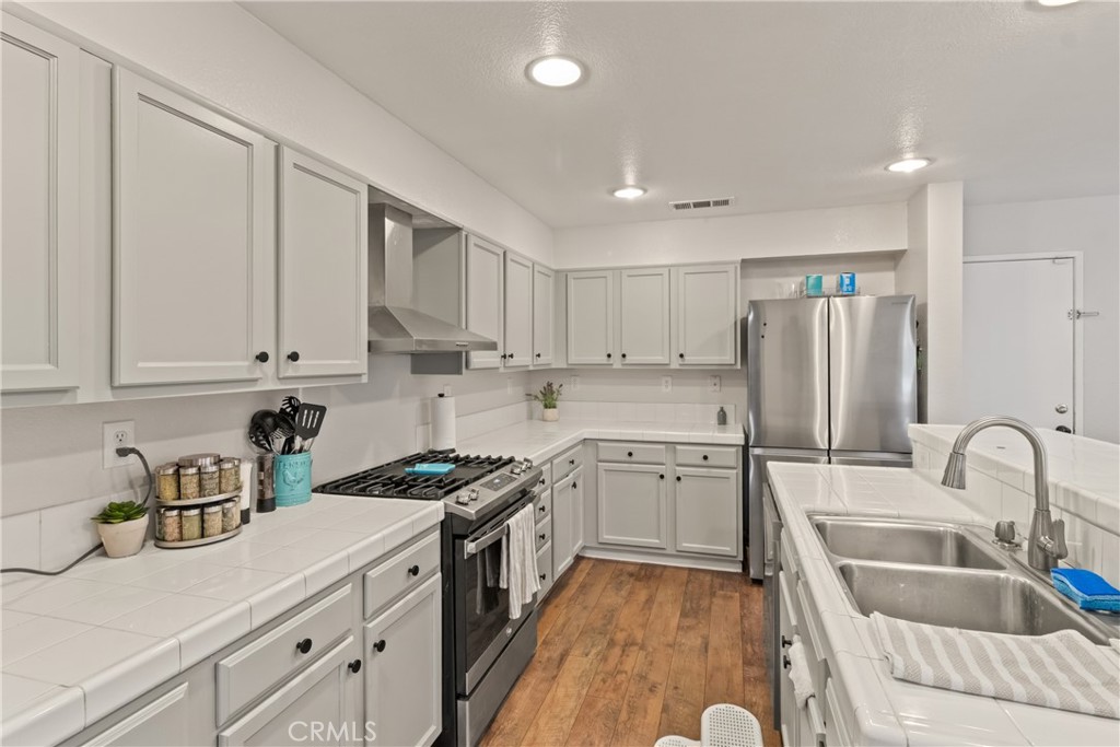 2614 Bellevue Way Palmdale, CA 93550 - Photo 13 of 28 a kitchen with granite countertop a sink stainless steel appliances and cabinets