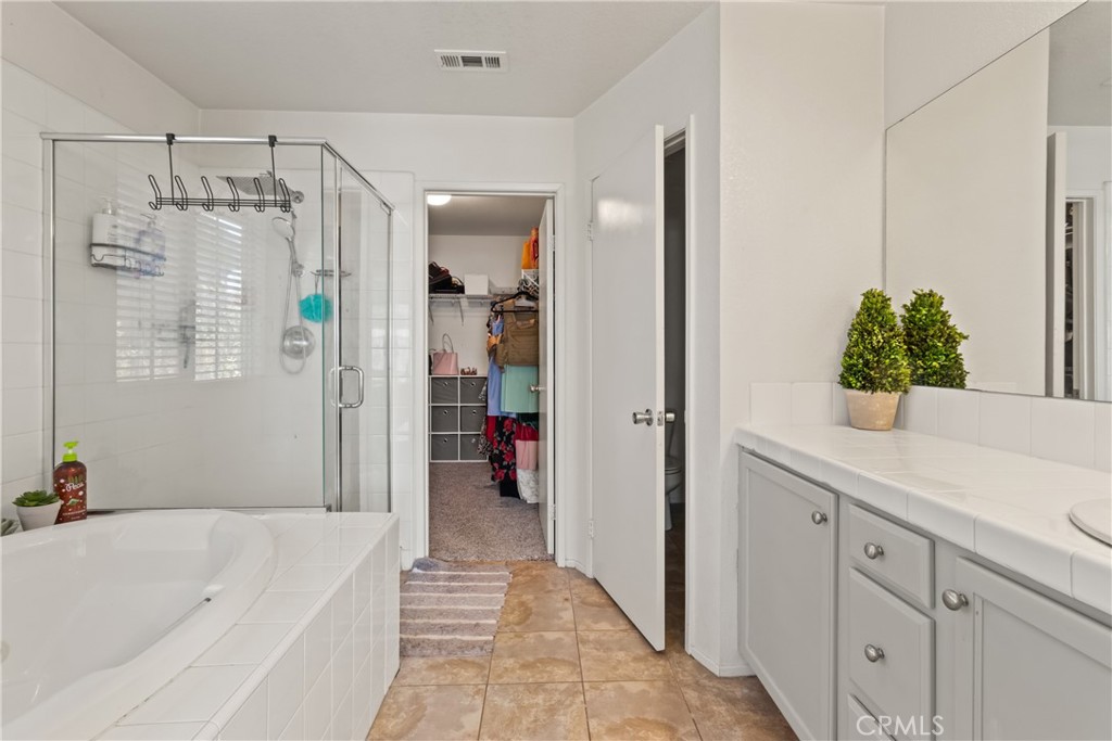 2614 Bellevue Way Palmdale, CA 93550 - Photo 19 of 28 a bathroom with a tub shower vanity and a sink