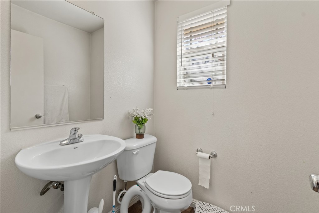 2614 Bellevue Way Palmdale, CA 93550 - Photo 7 of 28 a bathroom with a sink a toilet and a mirror