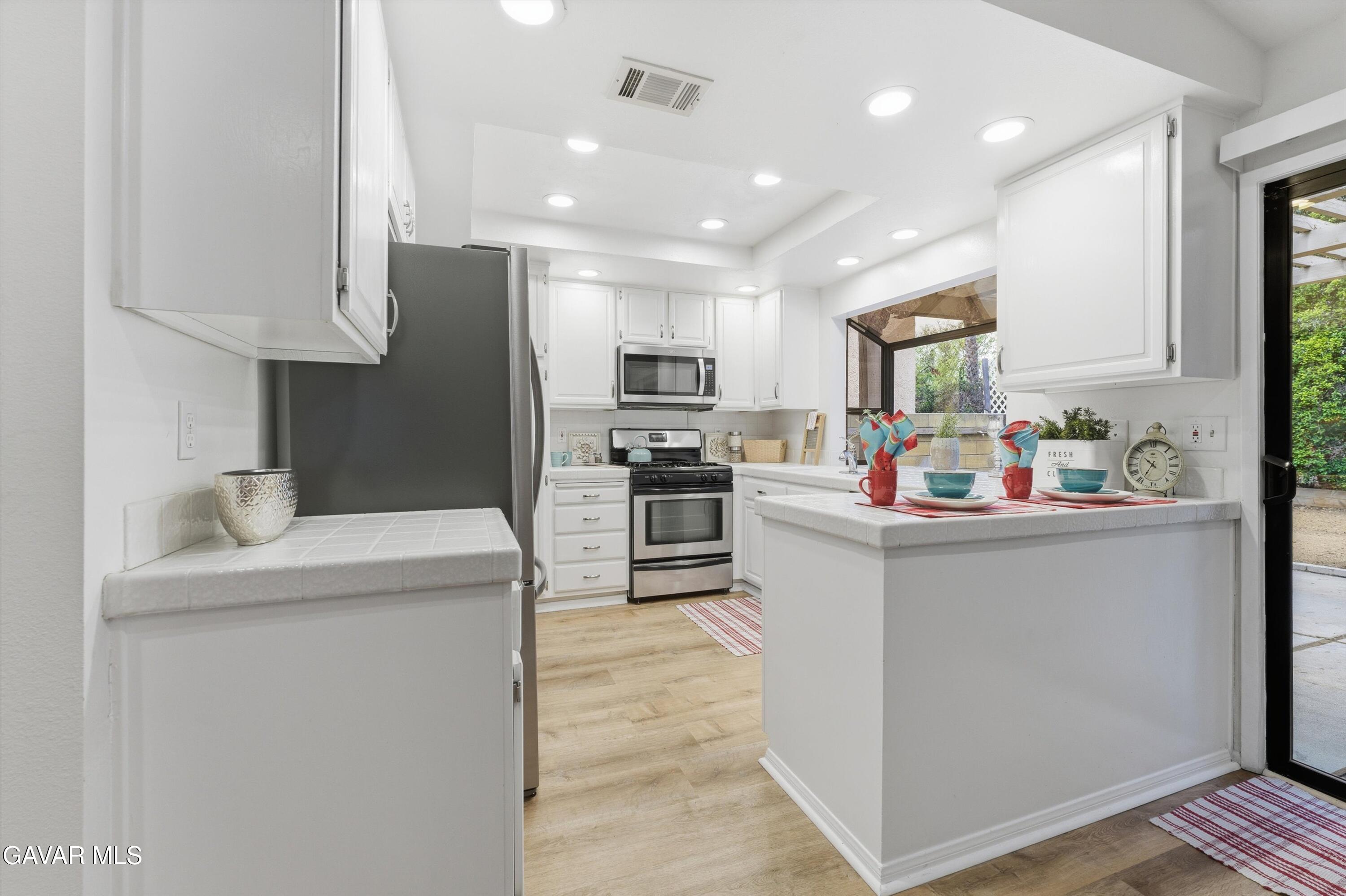 13611 Bear Valley Road Moorpark, CA 93021 - Photo 13 of 21 a kitchen filled with stainless steel appliances granite countertop a refrigerator sink and microwave