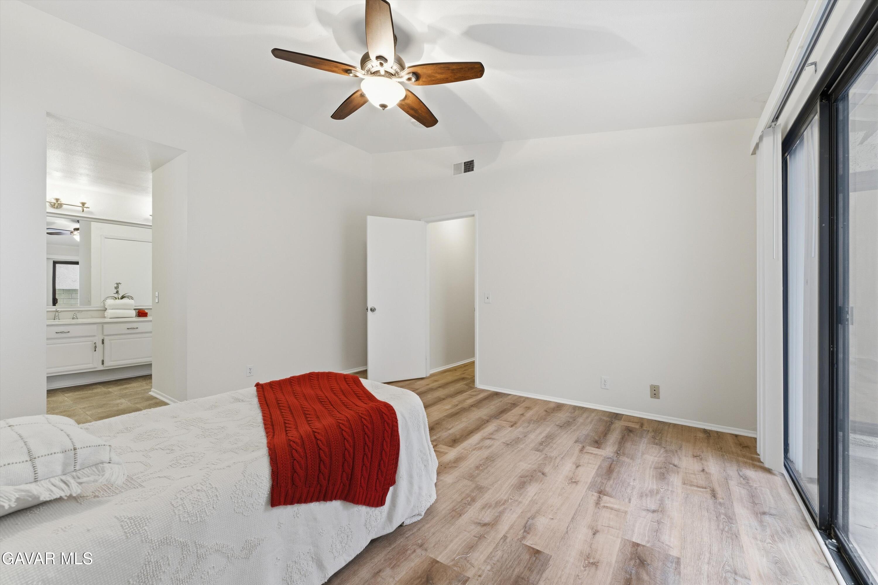 13611 Bear Valley Road Moorpark, CA 93021 - Photo 18 of 21 a bedroom with a bed and a chandelier