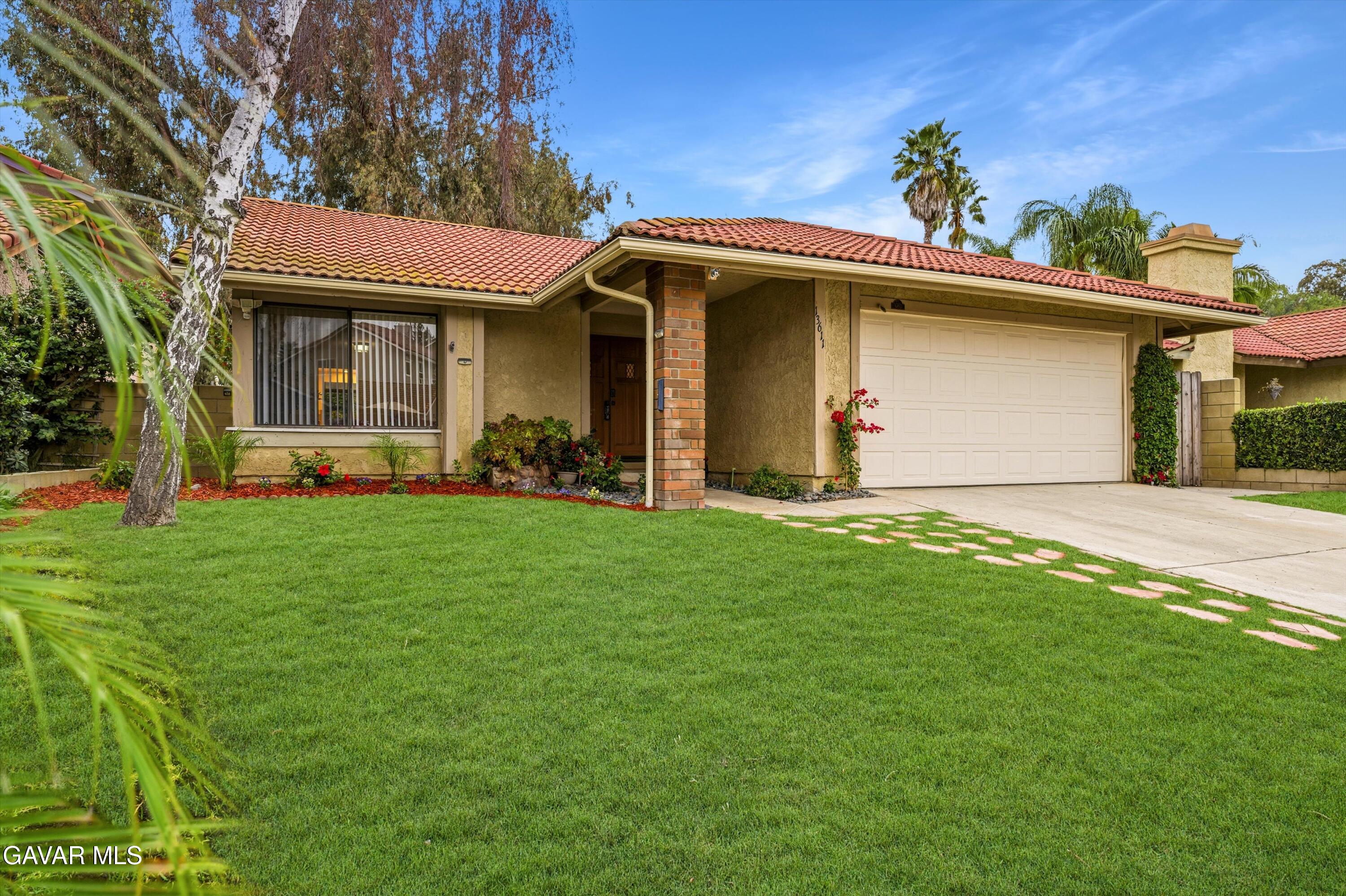 13611 Bear Valley Road Moorpark, CA 93021 - Photo 5 of 21 a front view of a house with a yard and garage