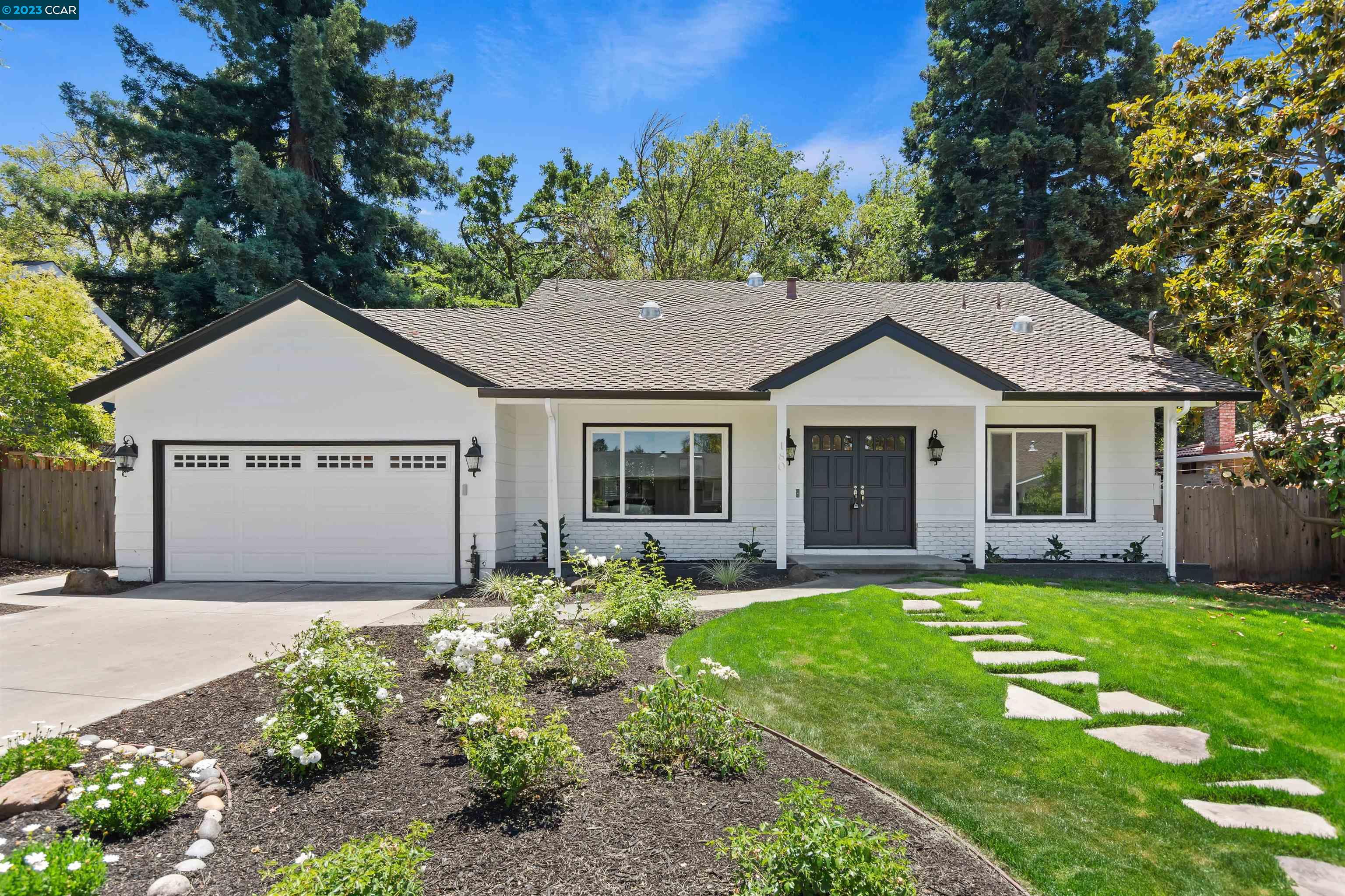 a front view of a house with a garden and yard