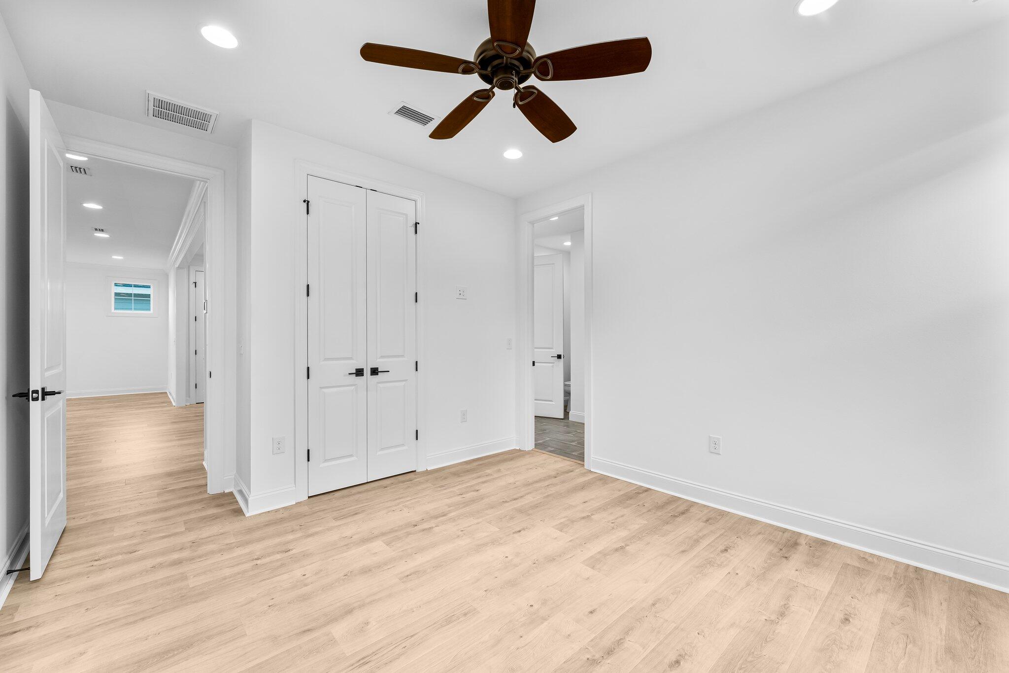 95 Conifer Ct Inlet Beach Inlet Beach, FL 32461 - Photo 20 of 33 an empty room with wooden floor ceiling fan and windows