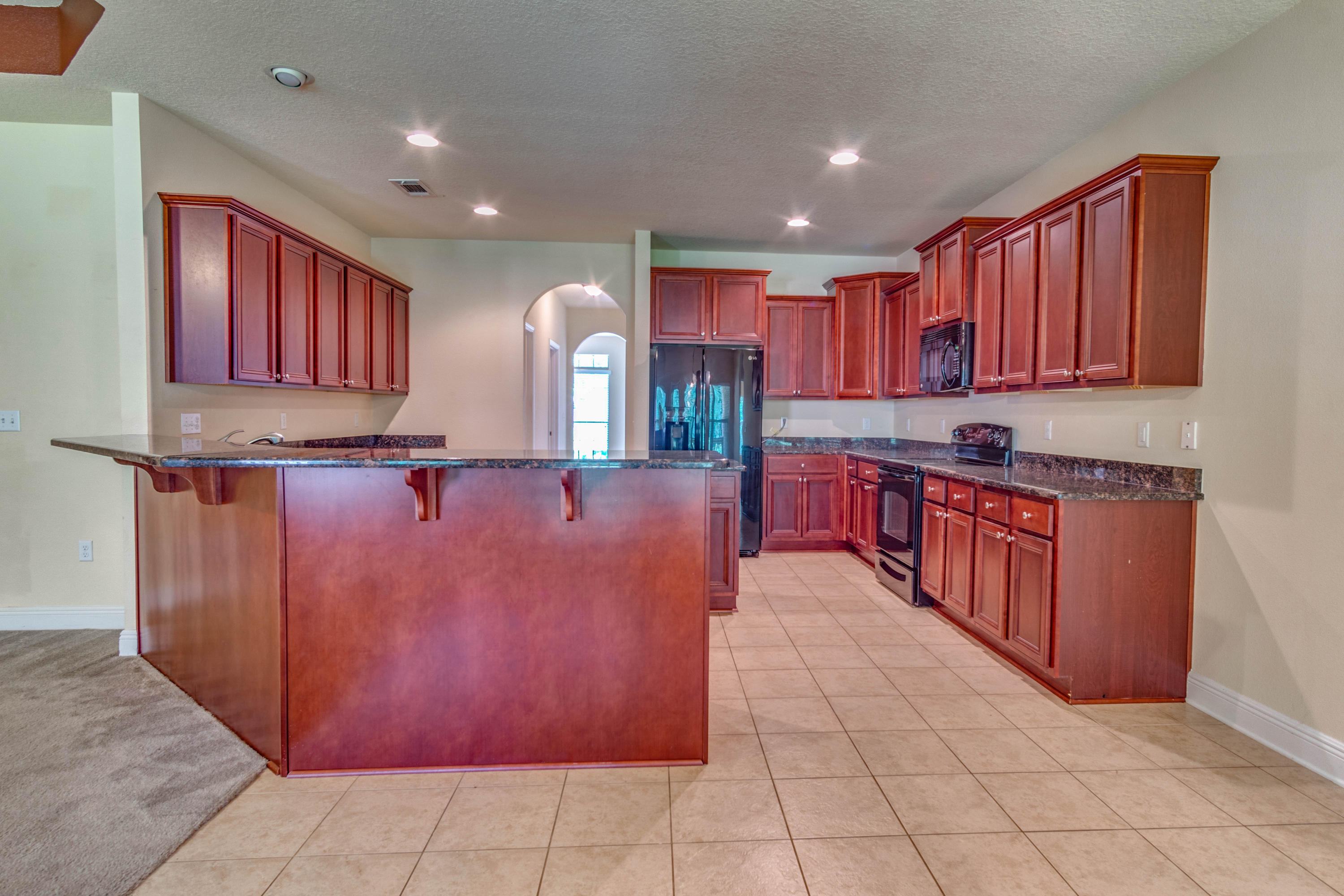642 Red Fern Road Crestview, FL 32536 - Photo 14 of 32 a open kitchen with kitchen island granite countertop wooden cabinets a sink and a counter top space