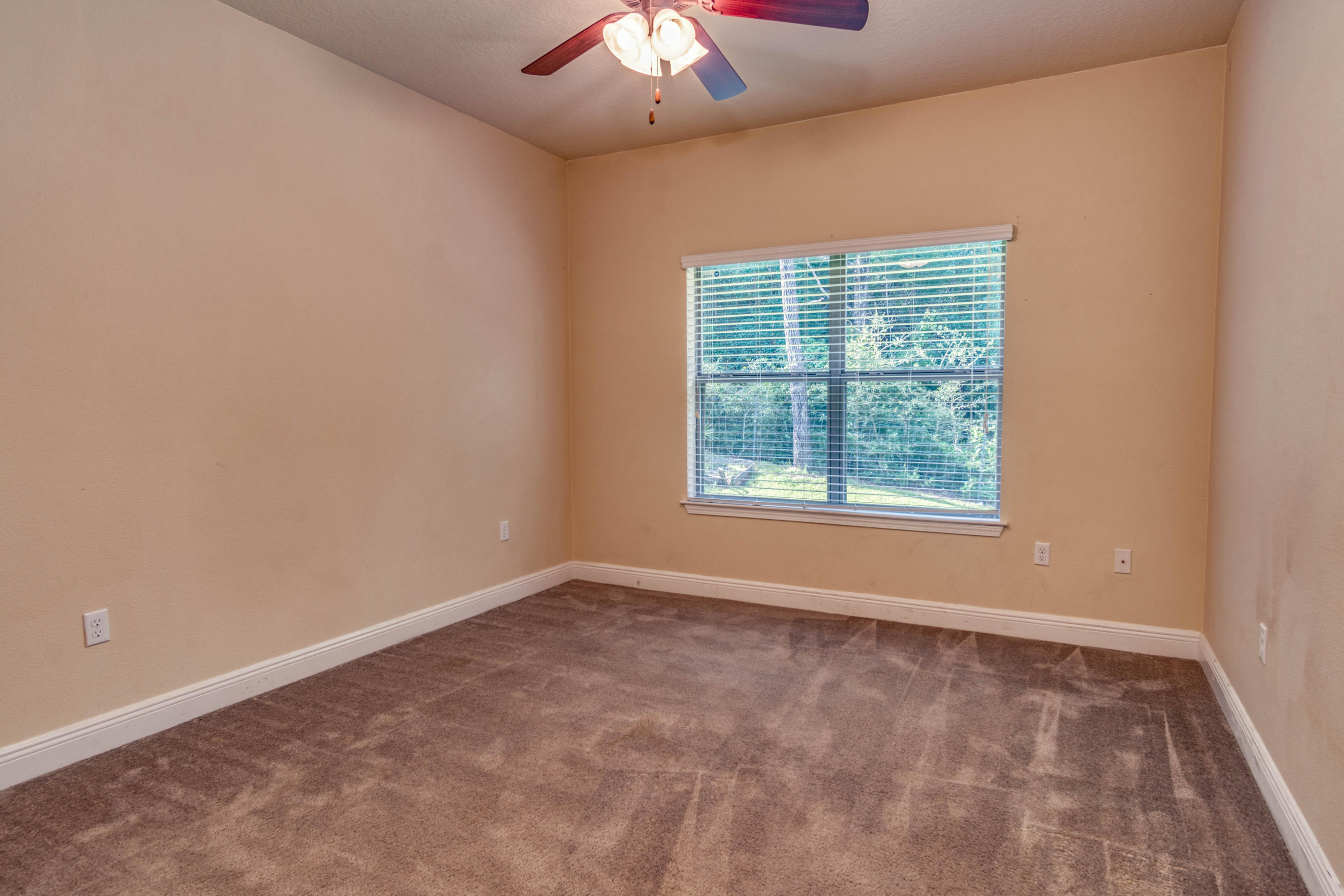 642 Red Fern Road Crestview, FL 32536 - Photo 22 of 32 an empty room with a chandelier fan and window