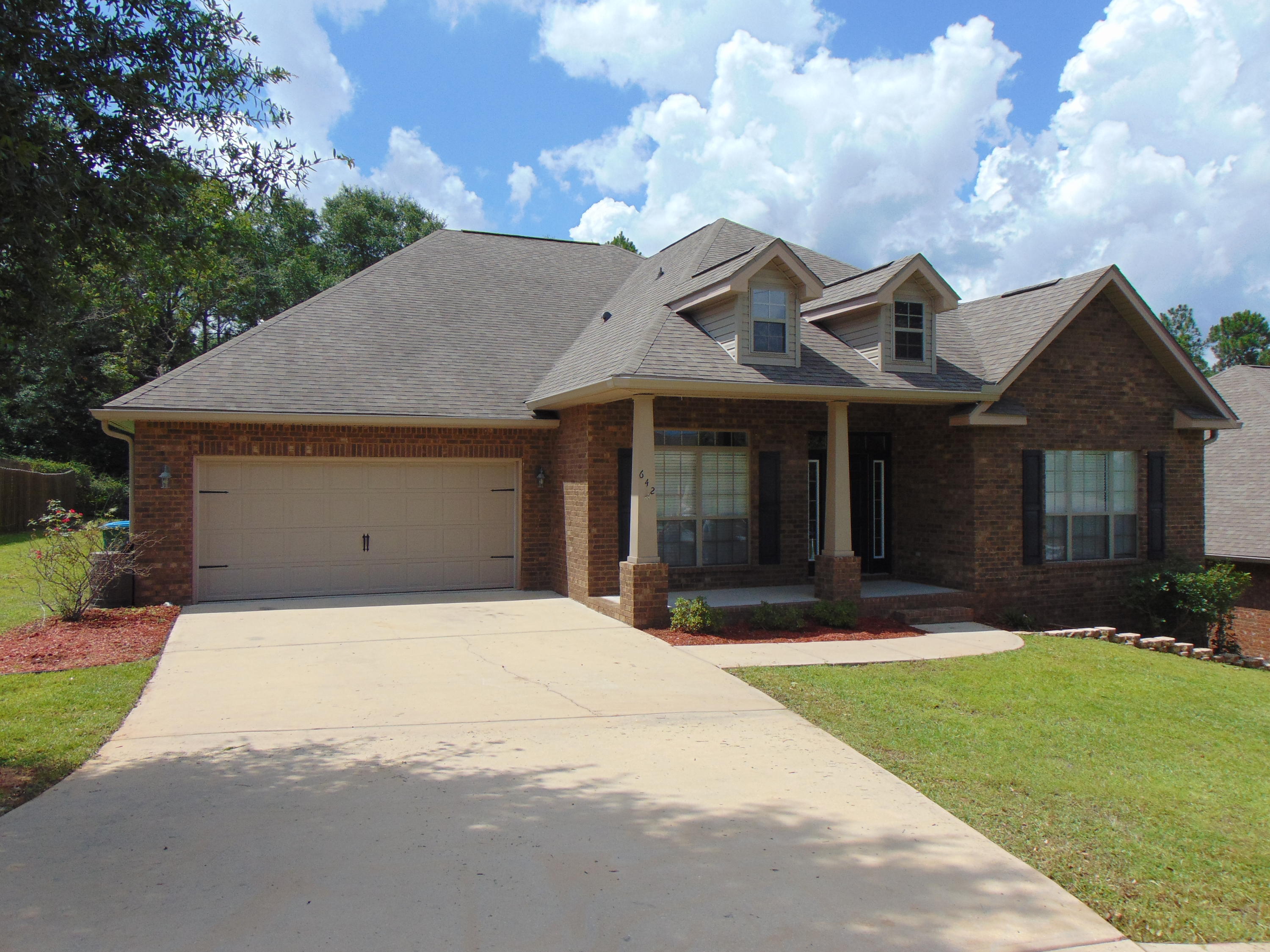 642 Red Fern Road Crestview, FL 32536 - Photo 3 of 32 a front view of a house with a garden and yard