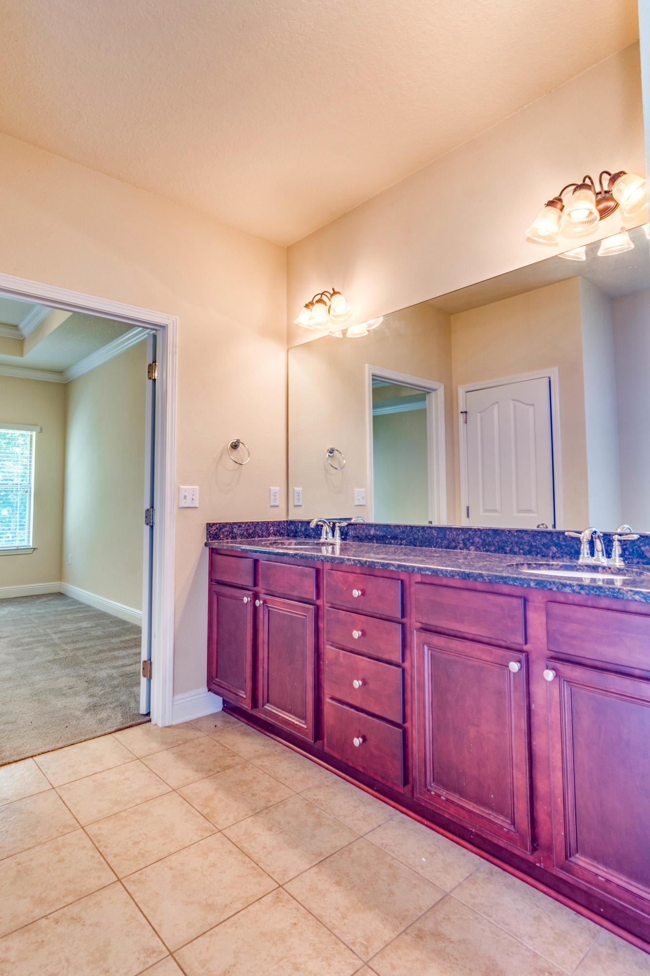 642 Red Fern Road Crestview, FL 32536 - Photo 31 of 32 a spacious bathroom with a granite countertop sink and a mirror