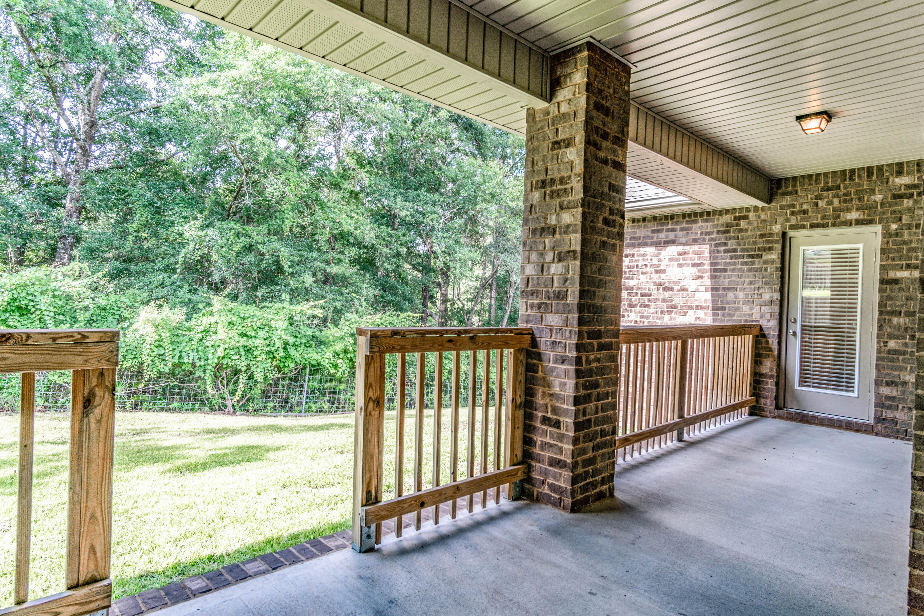 642 Red Fern Road Crestview, FL 32536 - Photo 4 of 32 a view of a porch with furniture and floor to ceiling window