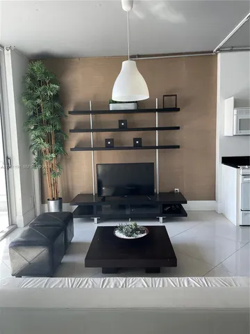 a living room with a fireplace and a potted plant