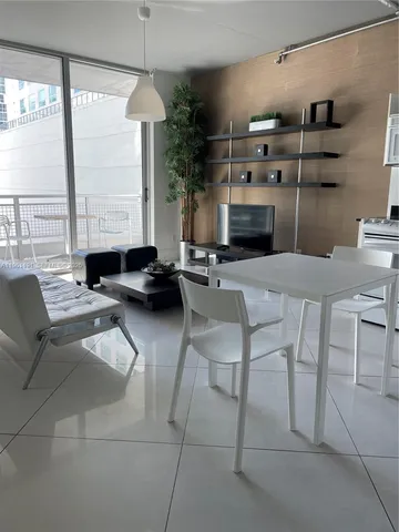 a dining room with furniture and a large window