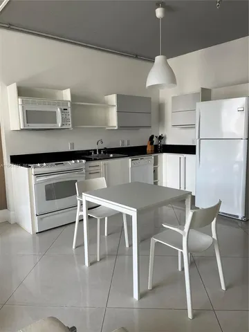 a kitchen with a stove a table and chairs