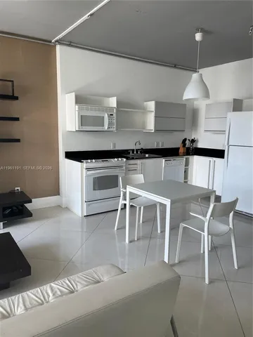 a kitchen with a stove a table and chairs