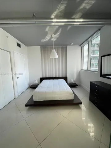 a spacious bedroom with a bed and a dresser