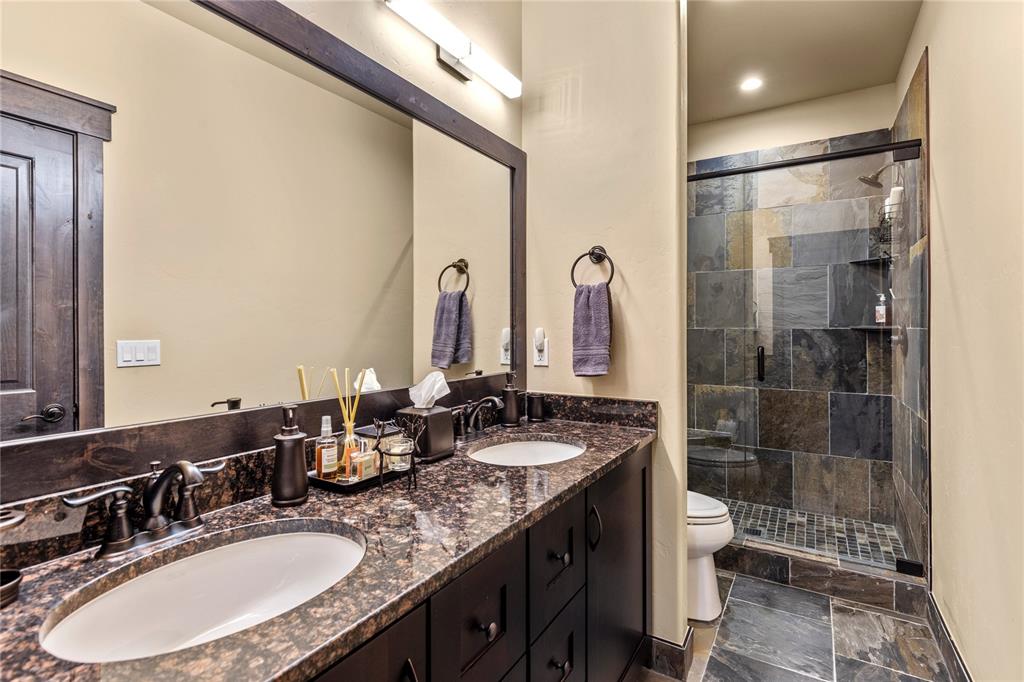 874 Independence Road, Unit 874 Keystone, CO 80435 - Photo 19 of 35 a bathroom with double vanity sinks a toilet a mirror and shower