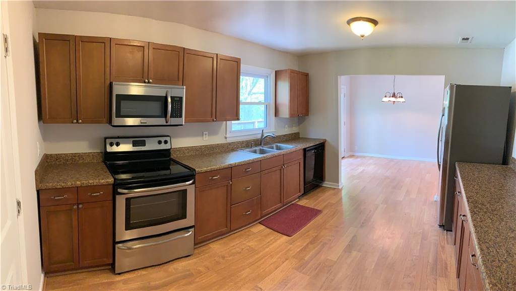 3896 Lewiston Road Summerfield, NC 27358 - Photo 7 of 16 Kitchen features cherry cabinetry, oodles of counter top space & stainless steel appliances.