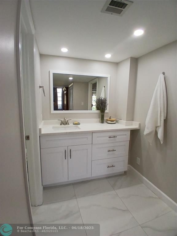 907 Cypress Terrace, Unit 104 Pompano Beach, FL 33069 - Photo 11 of 40 a bathroom with a double vanity sink and mirror