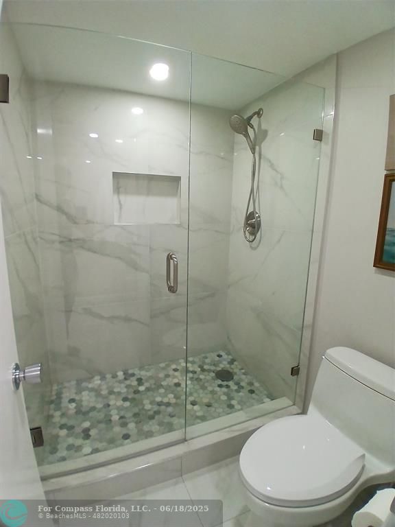 907 Cypress Terrace, Unit 104 Pompano Beach, FL 33069 - Photo 12 of 40 a white toilet sitting next to a bathroom