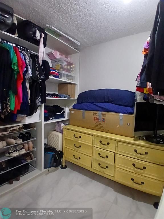 907 Cypress Terrace, Unit 104 Pompano Beach, FL 33069 - Photo 15 of 40 a view of walk in closet with clothes and shoes