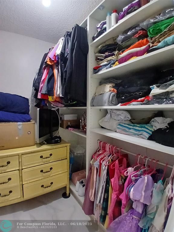 907 Cypress Terrace, Unit 104 Pompano Beach, FL 33069 - Photo 16 of 40 a view of walk in closet with clothes and shoes