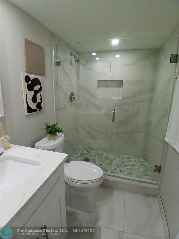 907 Cypress Terrace, Unit 104 Pompano Beach, FL 33069 - Photo 18 of 40 a bathroom with a sink a toilet and shower