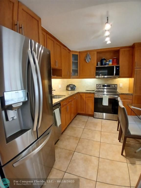907 Cypress Terrace, Unit 104 Pompano Beach, FL 33069 - Photo 2 of 40 a kitchen with stainless steel appliances granite countertop a sink stove and refrigerator