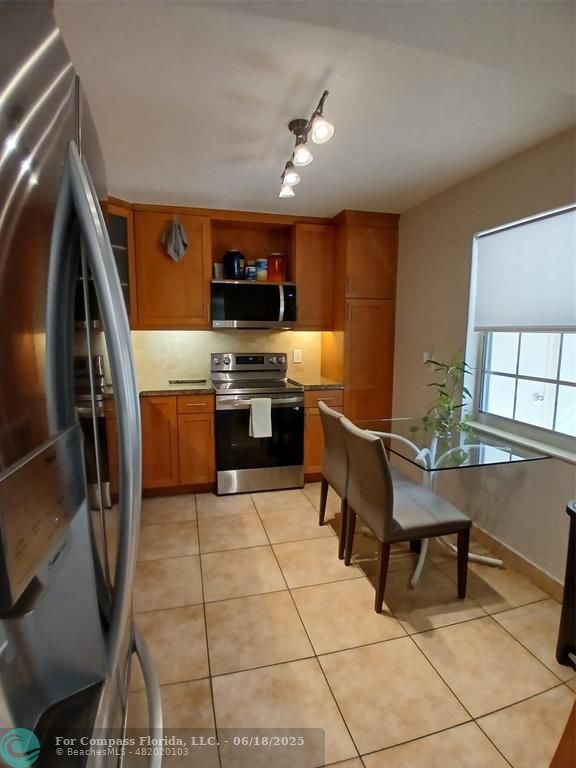 907 Cypress Terrace, Unit 104 Pompano Beach, FL 33069 - Photo 3 of 40 a kitchen with granite countertop a sink appliances and cabinets