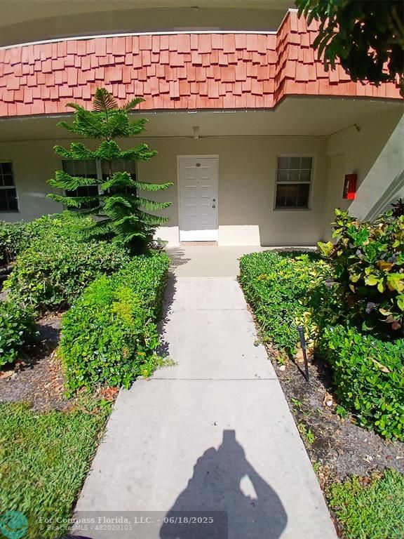 907 Cypress Terrace, Unit 104 Pompano Beach, FL 33069 - Photo 32 of 40 a front view of a house with garden
