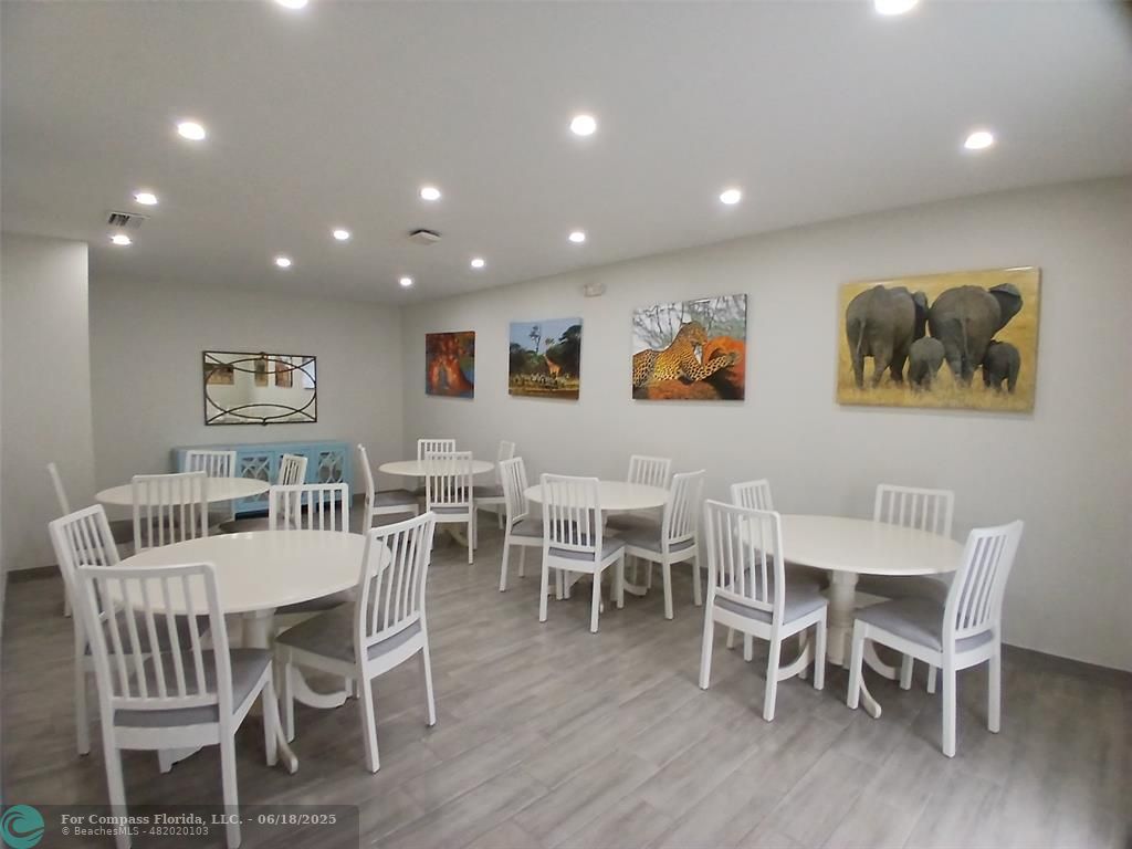 907 Cypress Terrace, Unit 104 Pompano Beach, FL 33069 - Photo 36 of 40 a view of a dining room with furniture wooden floor and chandelier