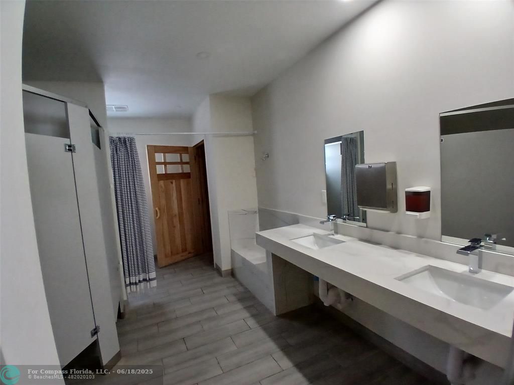 907 Cypress Terrace, Unit 104 Pompano Beach, FL 33069 - Photo 38 of 40 a bathroom with a double vanity sink and a mirror