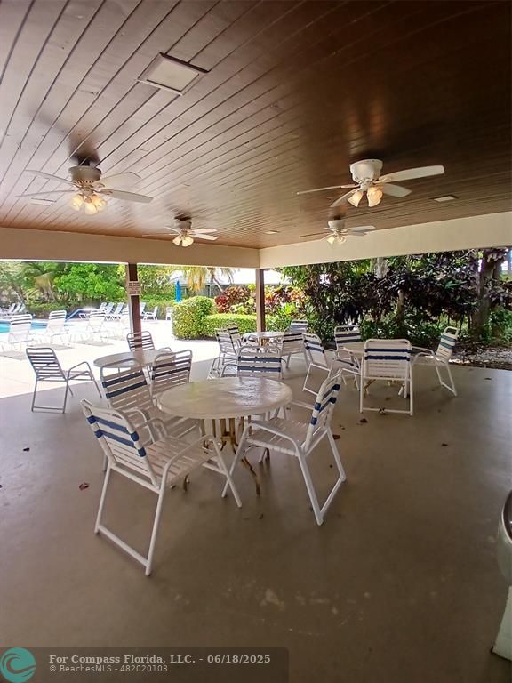907 Cypress Terrace, Unit 104 Pompano Beach, FL 33069 - Photo 39 of 40 a view of a patio with a table and chairs under an umbrella