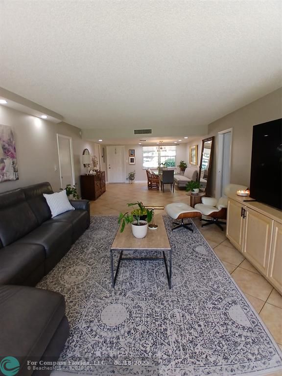 907 Cypress Terrace, Unit 104 Pompano Beach, FL 33069 - Photo 5 of 40 a living room with furniture a rug and a flat screen tv