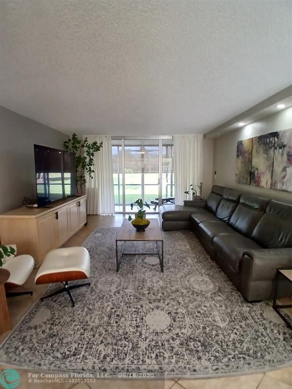 907 Cypress Terrace, Unit 104 Pompano Beach, FL 33069 - Photo 9 of 40 a living room with furniture and a rug