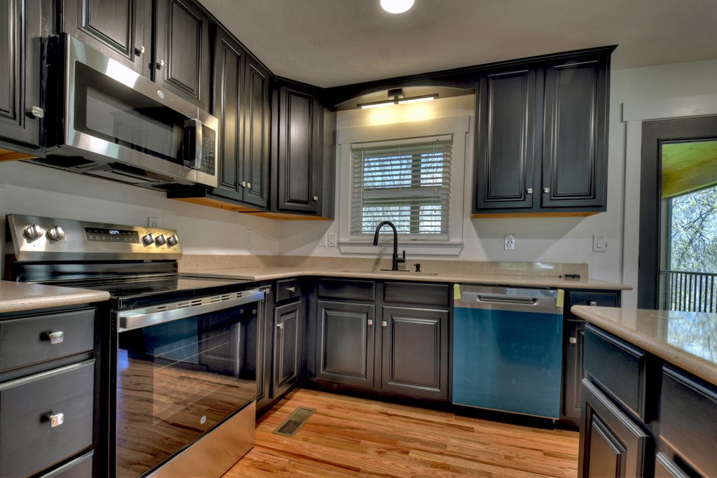 975 Goss Road Epworth, GA 30541 - Photo 21 of 59 a kitchen with stainless steel appliances granite countertop wooden cabinets a stove top oven a sink and dishwasher
