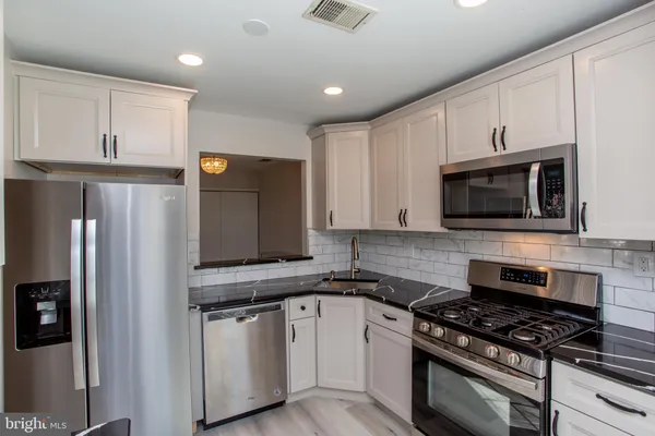 a kitchen with a sink a stove cabinets and a window