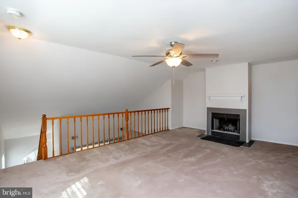 an empty room with a chandelier fan and a window