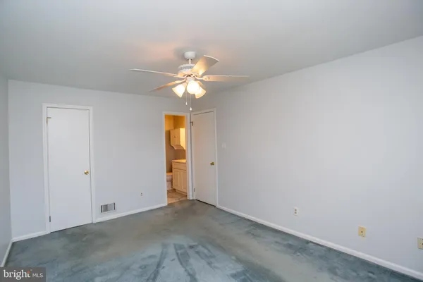 an empty room with a ceiling fan and a window