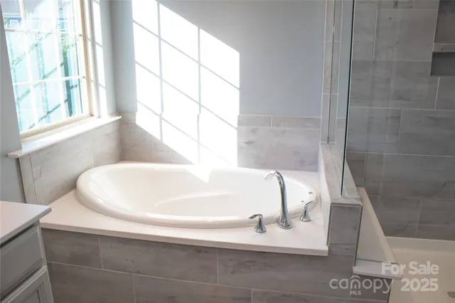 a white bath tub sitting in a bathroom next to a window
